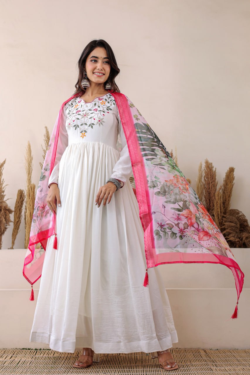 Elegant white Anarkali with floral embroidery, paired with a vibrant floral dupatta. Graceful, festive, and perfect for any celebration.
