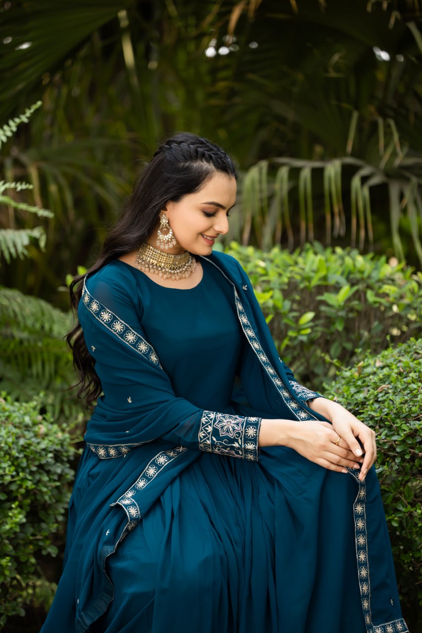 Step into timeless elegance with this stunning floor-length Anarkali gown in a deep teal blue shade.