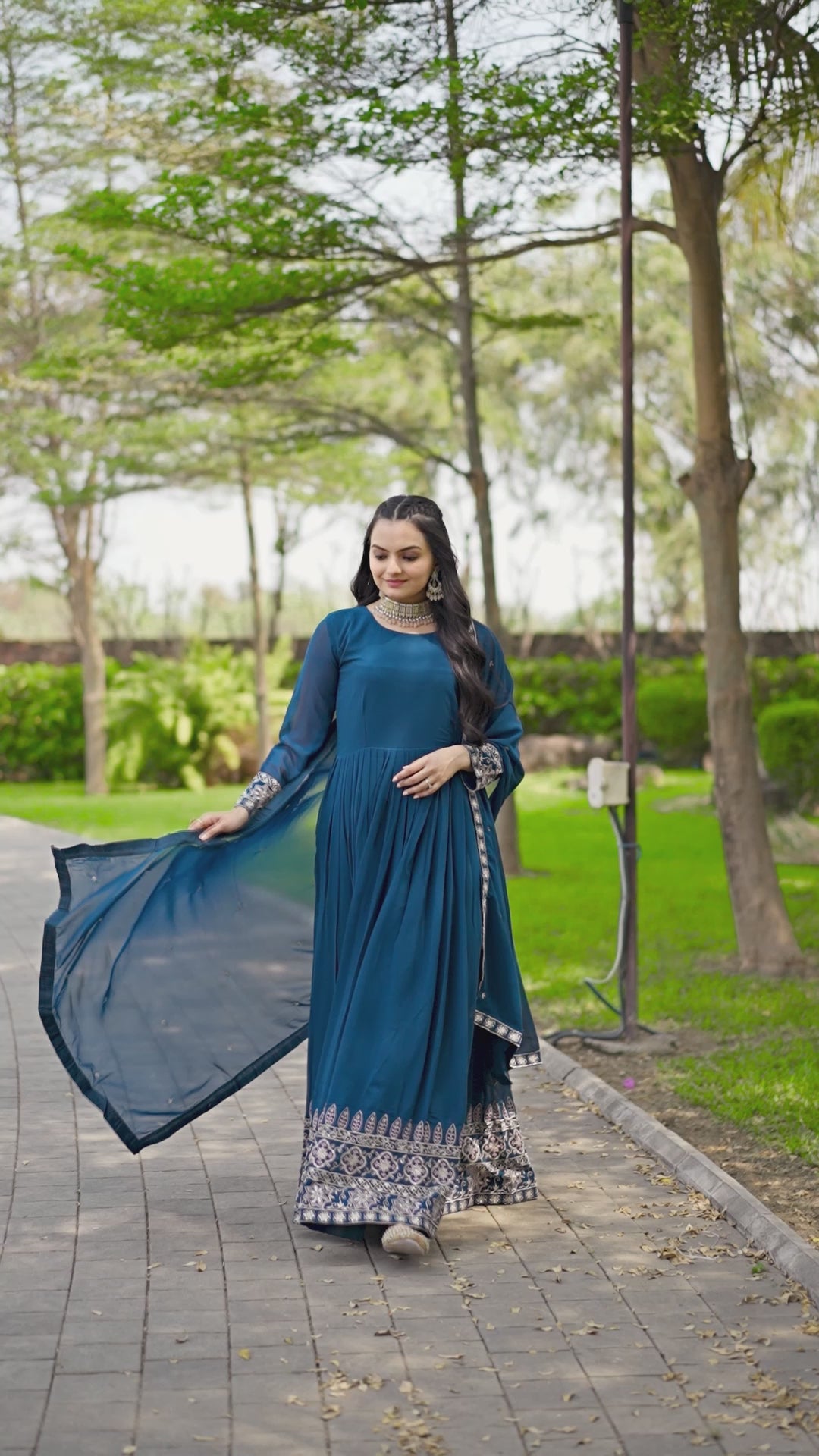 Step into timeless elegance with this stunning floor-length Anarkali gown in a deep teal blue shade.